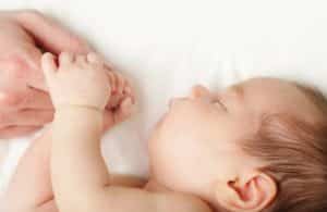 Baby sleeping holding dad's hand City Fertility - Baby