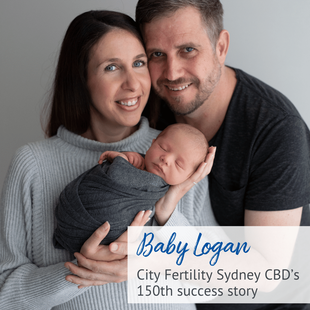 Woman and Man smiling at camera holding new born baby